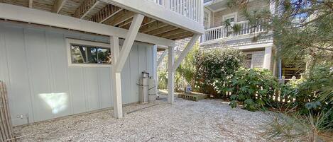 A two-story building with a covered deck and a gravel driveway.