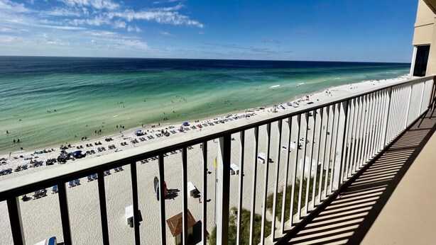 Ein Balkon mit Blick auf Strand und Meer.