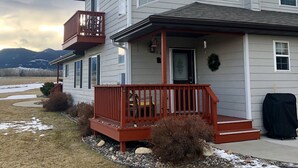 Une maison à deux étages avec un porche à l’avant et un balcon.