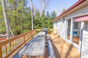 Enjoy al fresco dining on the deck, surrounded by a lush forest and equipped with a grill for outdoor cooking.