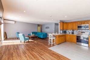 Relax in this stylish living space with a sofa, armchairs, and dining table.