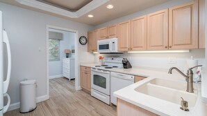 Une cuisine moderne avec des meubles en bois, un four à micro-ondes, une cuisinière et un évier.