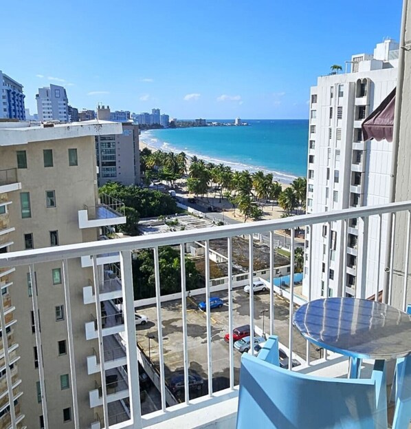 A balcony with a clear view of a beach and ocean.