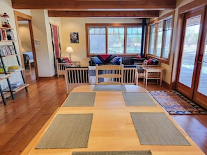 Relax in this serene room with a large window offering a view of the surrounding landscape, a comfortable seating area, and a bookshelf filled with books.