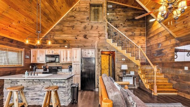 A wooden cabin interior with a kitchen, bar area, and a staircase. - "New Lake Cabin in an Incredibly Quiet Setting" (Langston)