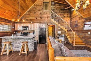 A wooden cabin interior with a kitchen, bar area, and a staircase. - "New Lake Cabin in an Incredibly Quiet Setting" (Langston)