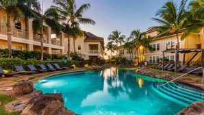 A resort pool with lounge chairs, palm trees, and a building with balconies. - Poipu Kai B111: Lovely Gardenview Villa w/Shared Pool, Spa & AC, Near Beaches (Koloa)