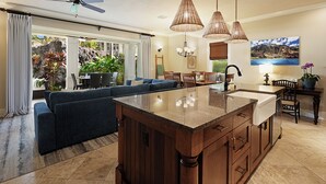 A spacious living area with a large island, a dining table, and a sofa. - Poipu Kai B111: Lovely Gardenview Villa w/Shared Pool, Spa & AC, Near Beaches (Koloa)