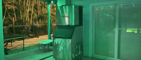 A kitchen area with a stainless steel appliance, a table, and chairs.