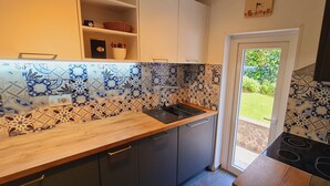 A kitchen with patterned tiles, a wooden countertop, a sink, and a stove. - Three Mermaids House, Piran (Piran)