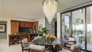 Una cocina moderna con armarios de madera, un televisor grande y un comedor con una mesa redonda y sillas.
