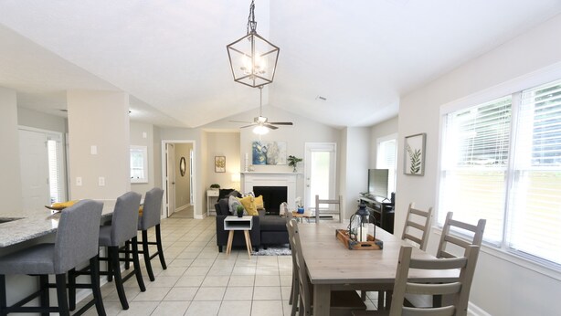 A spacious kitchen with a dining area, a fireplace, and a ceiling fan.