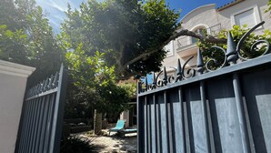 Una entrada protegida con un camino de piedra que conduce a un edificio con balcón.