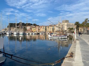 A marina with boats docked, a waterfront promenade, and buildings in the background. - L'Arche de Portissol comfort and Mediterranean Living Just Steps from the Sea (Sanary-sur-Mer)