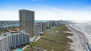 A high-rise hotel with multiple balconies, a pool area, and a beachfront view. - Phoenix Orange Beach II 604 by Liquid Life (Orange Beach)