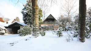 A wooden cabin with a sloped roof surrounded by snow-covered trees and a clear sky. - Weiße Höhen - Ferienhaus, Dibbersen bei Hamburg (Buchholz in der Nordheide)