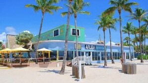 Ein Gebäude direkt am Strand, mit einem Schild mit der Aufschrift 'ARUBA'.