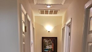 A hallway with wooden flooring, white walls, and a framed picture on the wall. - Fun In the Sun ~ Ocean Lakes  (Myrtle Beach)