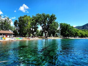 Une vue sur le lac, avec un quai, des bateaux et un bâtiment doté d’une porte rouge.