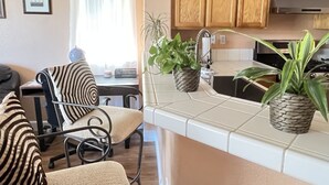 Una cucina moderna con mobili in legno, un lavello in acciaio inossidabile e due piante in vaso.
