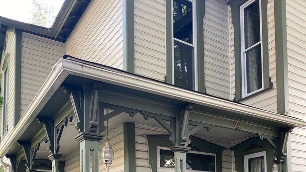 A two-story house with a porch, a front door, and a small bench. - Hillside Haven Historic Vacation Home in Deersville by Tappan & Clendening Lakes (Deersville)