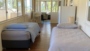 A room with two beds, a desk, and a chair.