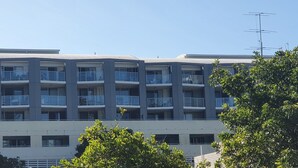 A multi-story building with balconies, likely an apartment complex. - Oceanview Escape at The Entrance (The Entrance)