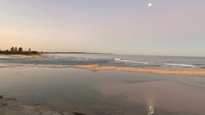 A beach with calm waters and a clear sky. - Oceanview Escape at The Entrance (The Entrance)