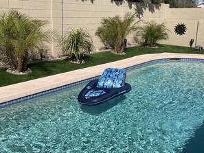 Une piscine aux eaux cristallines, avec un fauteuil de relaxation flottant à la surface.