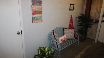 A room with a bench, a potted plant, and motivational wall art.