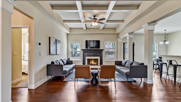 A spacious living room with a fireplace, two sofas, a coffee table, and a dining area with chairs. - 5br/3ba, sleeps 12! Newly renovated w/ media room! (Lawrenceville)