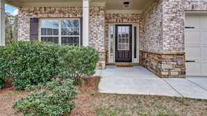 A two-story house with a brick facade, a front porch, and a garage. - 5br/3ba, sleeps 12! Newly renovated w/ media room! (Lawrenceville)