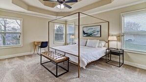 A four-poster bed with a bench, a desk, and a lamp in a bedroom with large windows and a ceiling fan. - 5br/3ba, sleeps 12! Newly renovated w/ media room! (Lawrenceville)