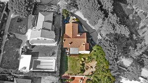 An aerial view of a residential area with multiple houses, a swimming pool, and a small garden area.