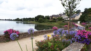 A riverside view with a stone wall and colorful flowers. - House (53m2) for vacations by the sea (La Forêt-Fouesnant)