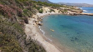 Un paisaje costero con aguas azul cristalino, costas rocosas y vegetación escasa.