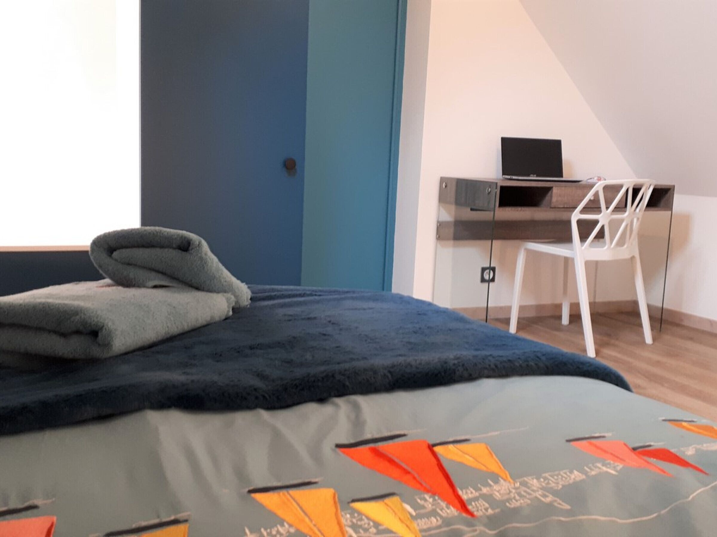 Une chambre à coucher avec un lit, un bureau et une chaise.