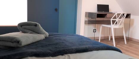 Une chambre à coucher avec un lit, un bureau et une chaise.