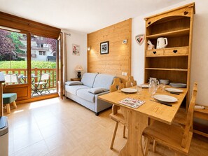 Ein Zimmer mit einem Holztisch, einer Couch und einer Holzkommode mit herzförmigen Ausschnitten.