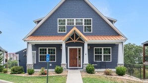 A two-story house with a gabled roof, a front porch, and a number 6 on the door. - Luxury 7BR Reunion Lodge on Thousand Hills Golf Course | Sleeps 22 | Near Highway 76 (Branson)