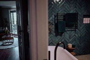 Une salle de bain avec un mur orné d’un motif en chevrons, un porte-serviettes et un lavabo.