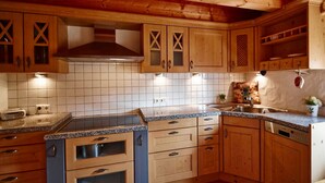 Une cuisine avec des armoires en bois, un comptoir en granit et un évier en acier inoxydable.