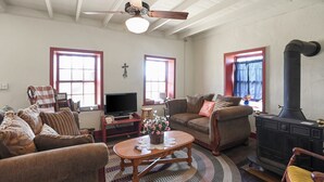 Un salon chaleureux avec une cheminée, un téléviseur et des fauteuils confortables.