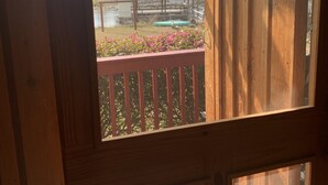 Un balcón de madera con vista a una casa y una piscina.
