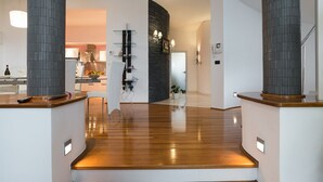 A modern kitchen with a central island, a dining area with chairs, and a kitchen counter with a phone and a bottle. - Villa Aylin, 5-bed, Next to the sea (Medulin)