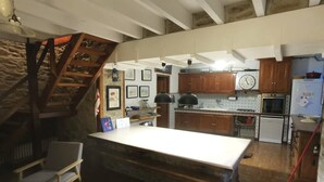 Un'ampia cucina con isola centrale, mobili in legno e una parete decorata in pietra.