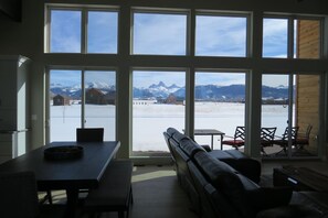 A room with large windows offering a view of a snowy landscape and mountains. - Indoor/Outdoor Living with 4-Peak Teton View (Driggs)
