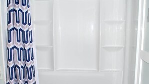 Une salle de bain avec douche, toilettes et porte-serviettes.
