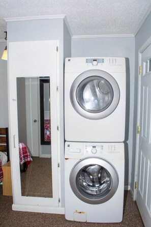 A compact laundry room with two stacked front-loading washing machines. - Winterplace E102 Ski in Ski out First Floor (Ghent)