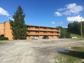 A multi-story building with a parking lot in front. - Winterplace E103 Ski in Ski out condo First floor (Ghent)